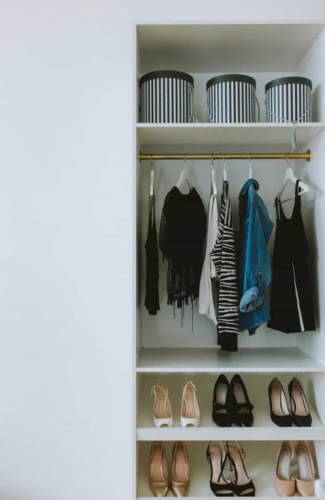 An organized closet with shirts and high heels.