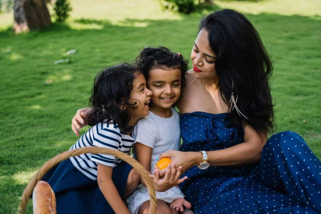 A mom and her 2 daughters on a picnic outside. Showing that the mom has more time because she paid for convenience. 