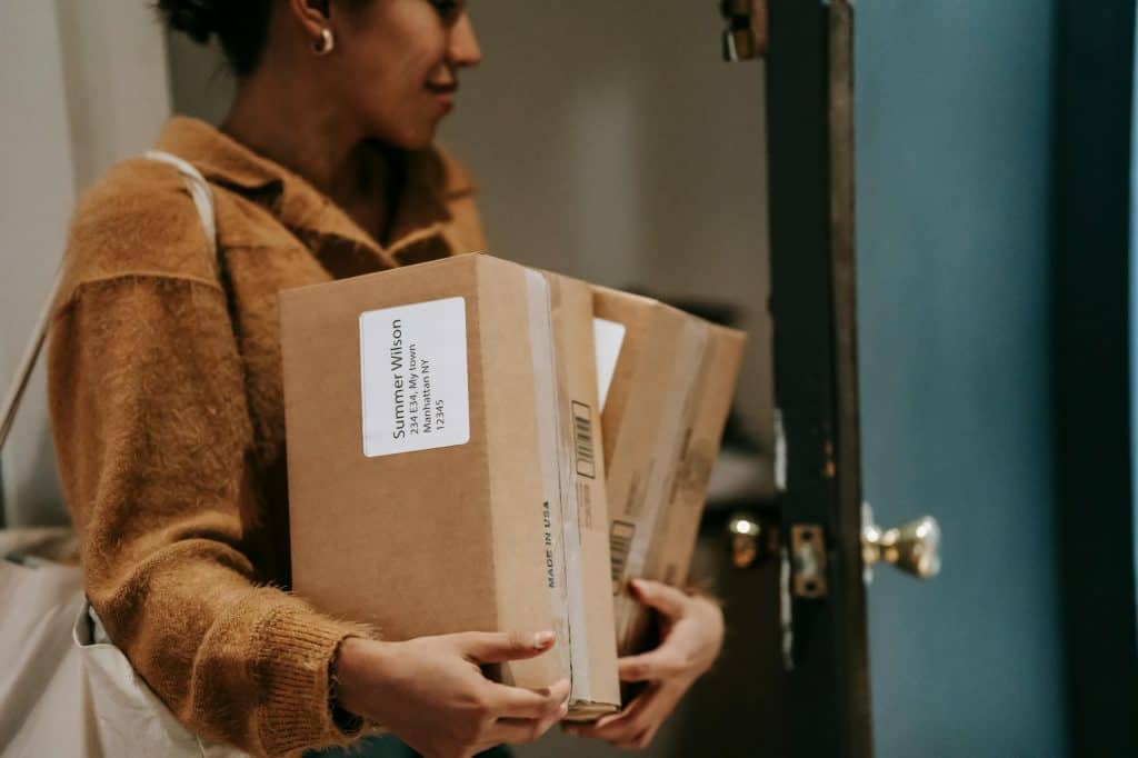 A woman bringing her packages that were delivered inside. 