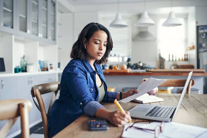 Woman sitting at table looking over her finances.  