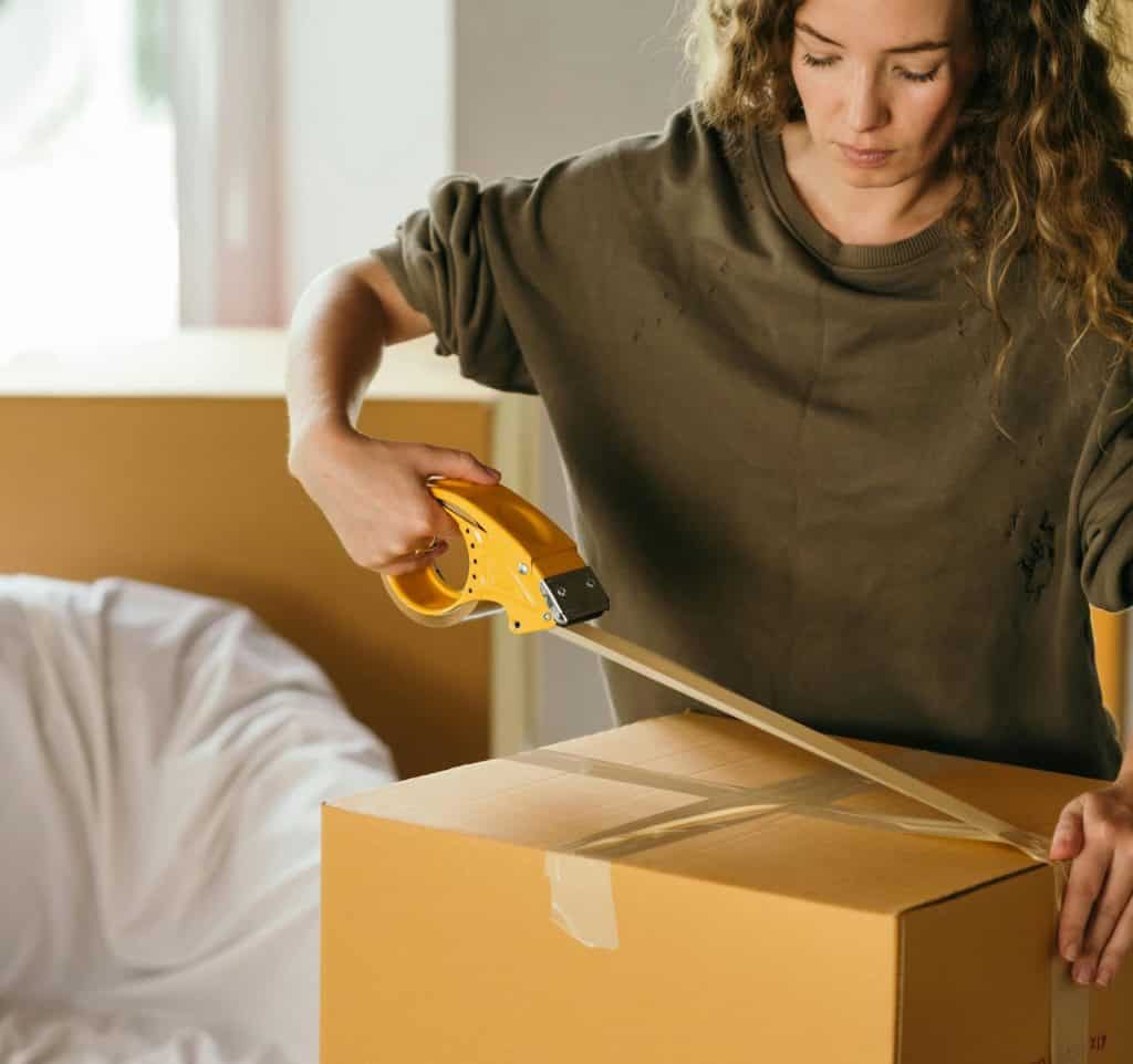 Women putting packing tape on a box she is getting ready to ship from eBay.
