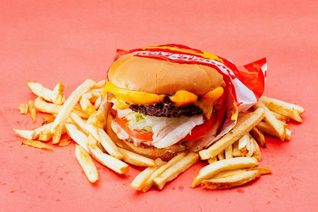 Image of a fast food burger and fries representing impulsive spending on food due to alcohol consumption.