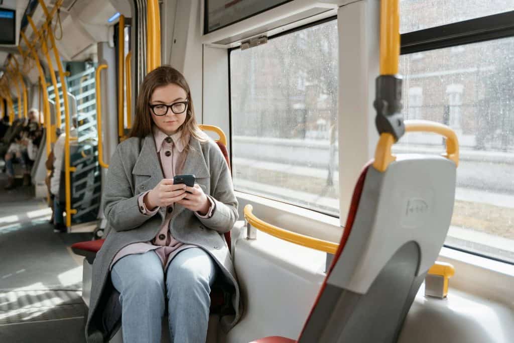 Image of a single mom with glasses taking public transportation to work to save money. 