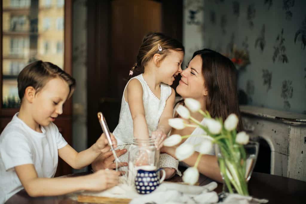 Image of a single mom with her 2 kids in the kitchen. 
